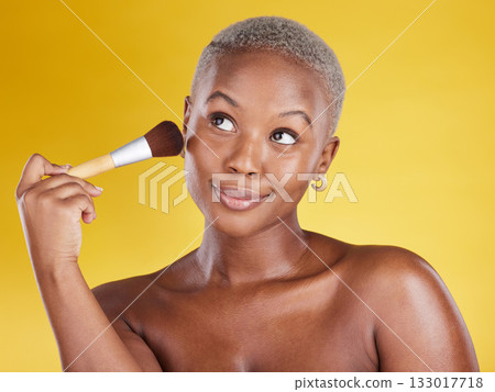 Face, makeup and beauty of black woman with brush in studio isolated on a yellow background. Thinking, cosmetics and happy African female model with tool to apply foundation or powder for facial skin Face, makeup and beauty of black woman with brush in studio isolated on a yellow background. Thinking, cosmetics and happy African female model with tool to apply foundation or powder for facial skin 133017718
