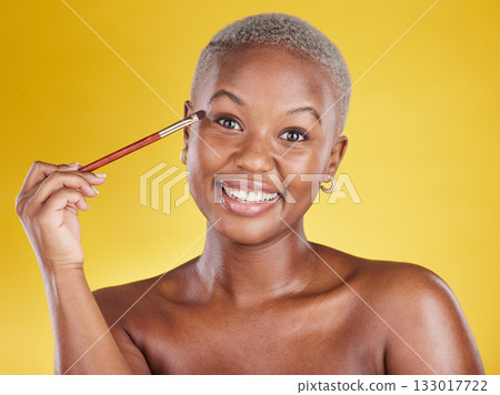 Beauty, cosmetics and portrait of black woman with brush in hand in studio and skincare isolated on yellow background. Happy makeup routine, eye shadow and smile, face of model with luxury product. 133017722