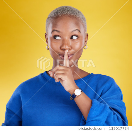 Secret, face and black woman with finger on lips in studio, background and privacy of drama news. Female model, silence and quiet on mouth, shush and gossip in whisper, emoji or confidential surprise 133017724