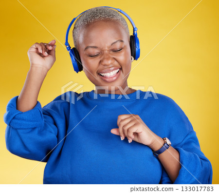 Music, headphones and black woman dance in studio isolated on a yellow background. Podcast, radio and happy African female streaming, enjoying and listening to audio, sound track or song for dancing. Music, headphones and black woman dance in studio isolated on a yellow background. Podcast, radio and happy African female streaming, enjoying and listening to audio, sound track or song for dancing. 133017783