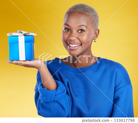 Smile, portrait and black woman with gift in studio isolated on a yellow background. Face, box and happy African female with present for celebration, party and holiday, birthday and special event. 133017798