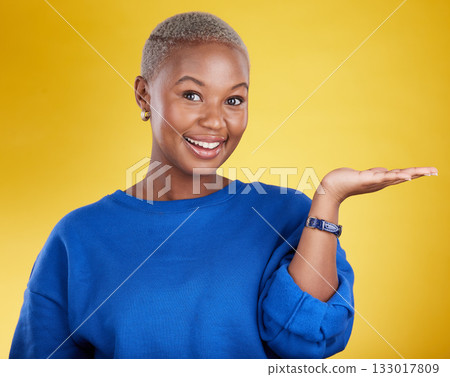 Portrait, smile and black woman with product placement palm in studio isolated on a yellow background. Mockup face, happy and African female with hand for advertising, marketing or branding space. Portrait, smile and black woman with product placement palm in studio isolated on a yellow background. Mockup face, happy and African female with hand for advertising, marketing or branding space. 133017809