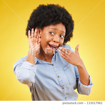 Surprise, gossip and black woman listening in a studio with a wow, wtf or omg face expression. Secret, shock and curious African female model with an afro with a listen gesture by a yellow background 133017962
