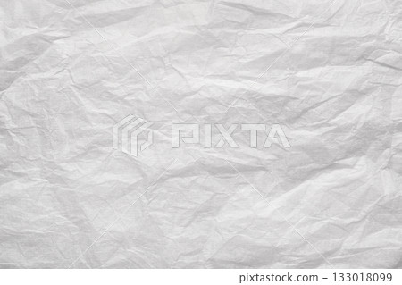Crumpled white paper sheet with creases and wrinkles forming textured, distressed abstract background with copy space and vintage feel 133018099