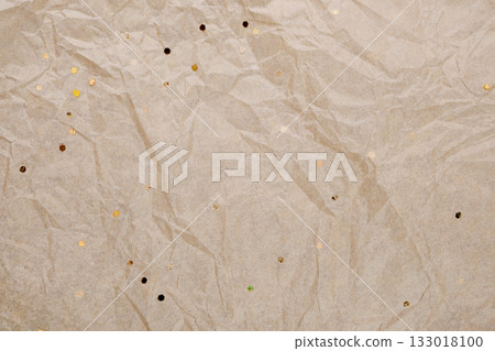 Crumpled brown kraft paper textured background with colorful tiny glitter particles 133018100