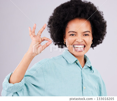Woman, afro and portrait smile with ok sign for satisfaction, approval or agreement against gray studio background. Happy female smiling and showing okay hand emoji, symbol or gesture for perfection 133018205