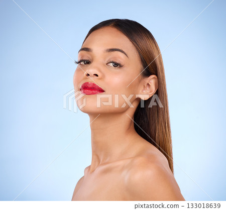 Beauty, woman and red lipstick makeup portrait with cosmetics on face in studio. Aesthetic female model person on a blue background for self care, facial glow and shine or color for skin and wellness Beauty, woman and red lipstick makeup portrait with cosmetics on face in studio. Aesthetic female model person on a blue background for self care, facial glow and shine or color for skin and wellness 133018639
