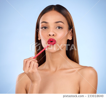 Woman, beauty and red lipliner or lipstick portrait for lips with cosmetics on face in studio. Aesthetic female model on blue background for self care, facial glow and pencil application for skin Woman, beauty and red lipliner or lipstick portrait for lips with cosmetics on face in studio. Aesthetic female model on blue background for self care, facial glow and pencil application for skin 133018640