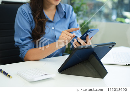 Business woman sitting front tablet ,laptop computer with financial graphs and statistics on monitor. Business woman sitting front tablet ,laptop computer with financial graphs and statistics on monitor. 133018690