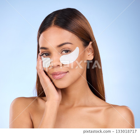 Skincare, collagen pads and portrait of woman with eye mask for anti aging skin glow on blue background. Cosmetics, facial repair and face of beauty model with wrinkle treatment product in studio. 133018717