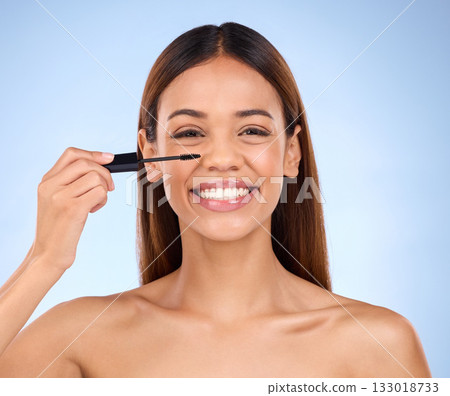 Beauty portrait, woman and mascara makeup with a smile for cosmetics on face in studio. Female model on blue background for self care, facial glow and eyelash extension or growth with luxury product Beauty portrait, woman and mascara makeup with a smile for cosmetics on face in studio. Female model on blue background for self care, facial glow and eyelash extension or growth with luxury product 133018733