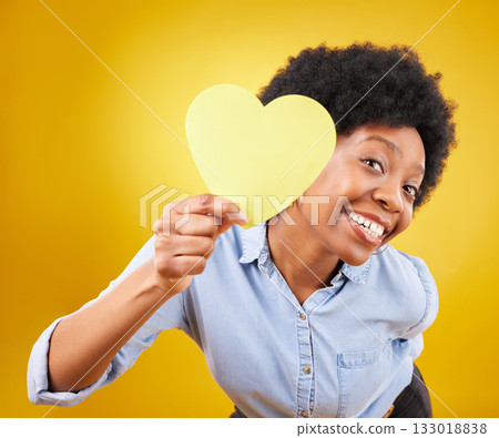 Portrait, heart and social media with a black woman in studio on a yellow background for love or affection. Emoji, shape and romance with an attractive young female feeling excited for valentines day 133018838