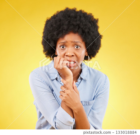 Fear, anxiety and biting nails with portrait of black woman in studio for scared, worry and nervous. Terror, problem and mental health with female on yellow background for stress, confused and crisis Fear, anxiety and biting nails with portrait of black woman in studio for scared, worry and nervous. Terror, problem and mental health with female on yellow background for stress, confused and crisis 133018884