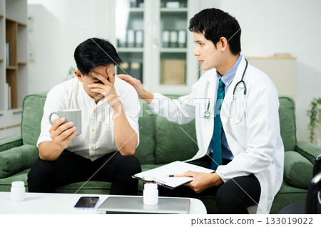 Doctor consulting with a stressed male patient in private clinic. Mental health care, therapy, empathy, and emotional support 133019022