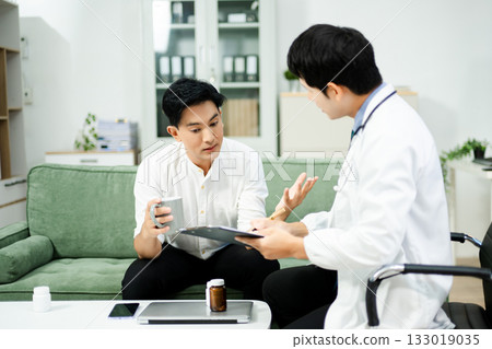 Caring doctor supports stressed male patient during mental health consultation on sofa. Therapy, empathy, and emotional care 133019035