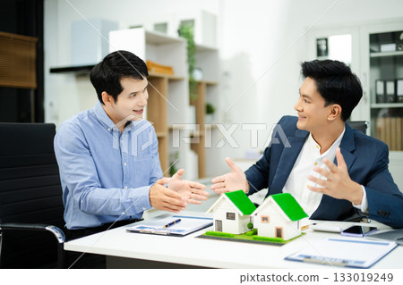 Professional team collaboration in modern office, discussing real estate model and signing contract, concept of startup 133019249