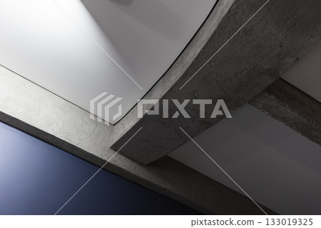 A striking interior detail featuring curved concrete beams crossing white panels A striking interior detail featuring curved concrete beams crossing white panels 133019325