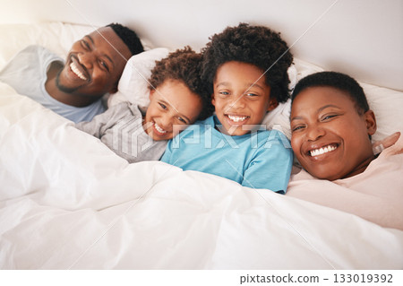 Smile, happy and relax with black family in bedroom for bonding, wake up and morning routine from top view. Care, funny and cute with parents and children at home for calm, weekend and quality time Smile, happy and relax with black family in bedroom for bonding, wake up and morning routine from top view. Care, funny and cute with parents and children at home for calm, weekend and quality time 133019392