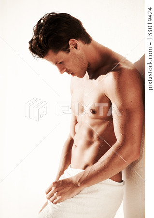 Sexy, body and shirtless man in a towel while thinking, handsome and clean. Strong, fitness and young male model posing topless with water drops, beauty and motivation or inspiration after shower 133019424
