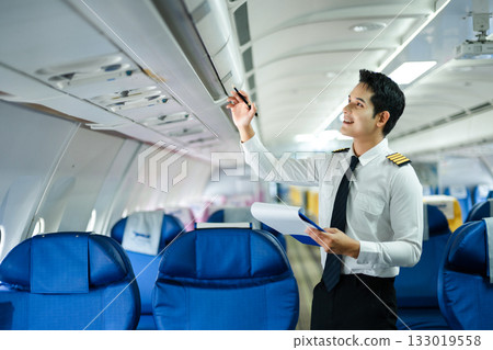 Professional airline pilot inspecting airplane cabin during safety check, perfect for aviation, travel, and airline safety concept stock photography 133019558