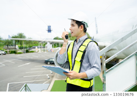 Aviation engineer inspects airplane for safety compliance. Professional aerospace technician at work in airport maintenance 133019676