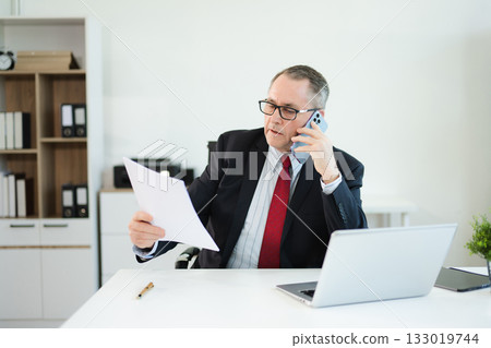 Professional businessman working at office with laptop, tablet, and notes. Perfect for business, finance, accounting, 133019744