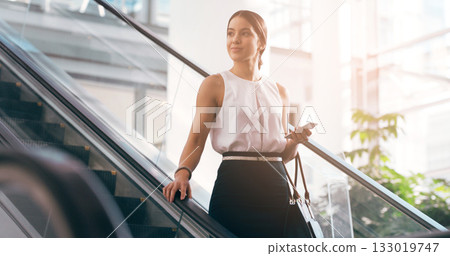 Business, thinking and woman with a smartphone, escalator and connection for social media, texting and sms. Female person, employee and agent on a moving stairway, cellphone and ideas with thoughts 133019747