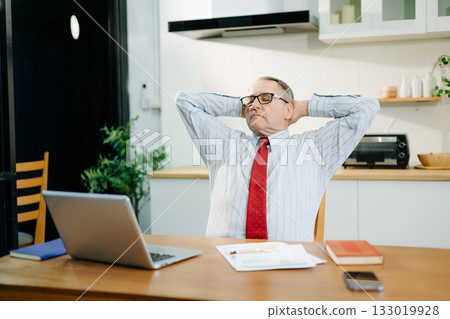 Mature Businessman using laptop while sitting at home. man sitting in kitchen 133019928
