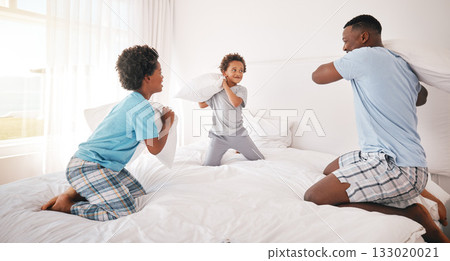 Black family, pillow fight and father with children on bed for bonding, quality time and relax together. Love, happy and African dad laughing, playing and enjoy morning with kids in bedroom at home 133020021