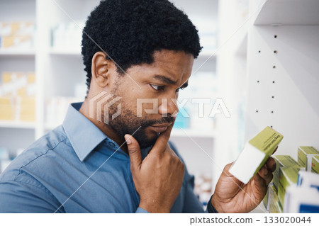 Black man, shopping or box in pharmacy for medicine, reading or pills in retail healthcare in store. African customer, decision or sale for health, deal or thinking for benefits of medical product Black man, shopping or box in pharmacy for medicine, reading or pills in retail healthcare in store. African customer, decision or sale for health, deal or thinking for benefits of medical product 133020044