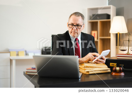 Mature Male judge in a courtroom on white table and Counselor or Male lawyer working in office. Justice and law concept 133020046