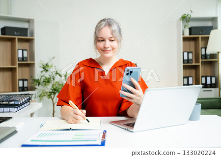 Confident business expert attractive smiling young woman holding digital tablet on desk in creative office. Confident business expert attractive smiling young woman holding digital tablet on desk in creative office. 133020224