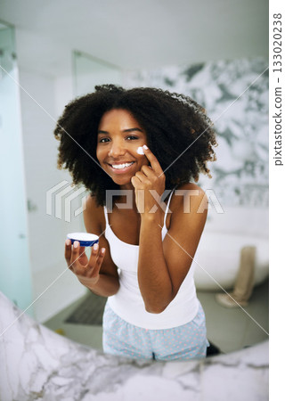 Skincare, smile and portrait of black woman in bathroom mirror with cream, dermatology and morning routine. Health, wellness and luxury skin care at home, happy girl in reflection with lotion on face Skincare, smile and portrait of black woman in bathroom mirror with cream, dermatology and morning routine. Health, wellness and luxury skin care at home, happy girl in reflection with lotion on face 133020238