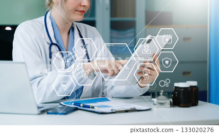 Dentist using tablet and digital interfaces for modern dental care, showcasing innovative technology, advanced healthcare, and professional oral treatment solutions. 133020276