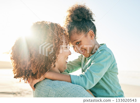 Family, mother and child hug at beach, travel and summer with sunshine lens flare and together outdoor. Trust, support with woman and girl smile on vacation, love and care in nature with happiness 133020543