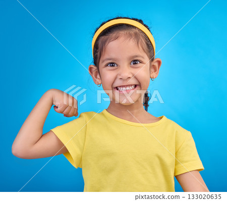 Strong, happy and portrait of a child with muscle isolated on a blue background in a studio. Excited, smile and girl kid showing biceps, arms and power from exercise with confidence on a backdrop Strong, happy and portrait of a child with muscle isolated on a blue background in a studio. Excited, smile and girl kid showing biceps, arms and power from exercise with confidence on a backdrop 133020635