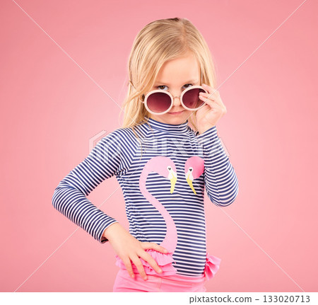 Holiday, portrait of child in studio with sunglasses and fun clothes isolated on pink background. Summer, vacation and fashion for children, girl in Australia on travel in serious face and beachwear Holiday, portrait of child in studio with sunglasses and fun clothes isolated on pink background. Summer, vacation and fashion for children, girl in Australia on travel in serious face and beachwear 133020713