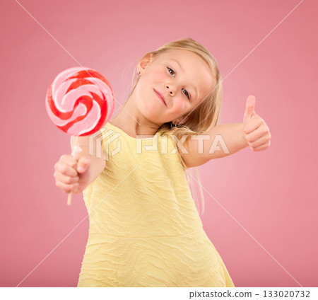 Candy, thumbs up and lollipop with portrait of girl in studio for sugar, party and carnival food isolated on pink background. Cute, positive and youth with child or eating snack for playful and treat Candy, thumbs up and lollipop with portrait of girl in studio for sugar, party and carnival food isolated on pink background. Cute, positive and youth with child or eating snack for playful and treat 133020732