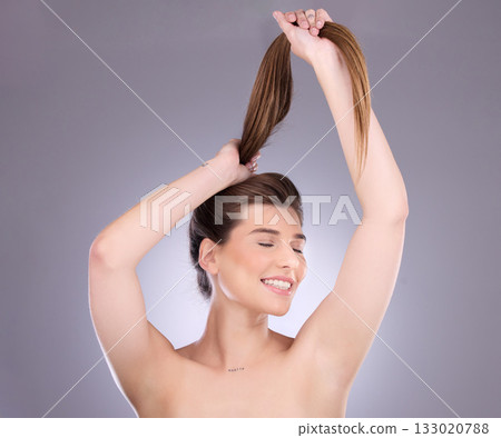 Eyes closed, beauty and hair care of a woman in studio isolated on a gray background. Cosmetics, growth or happy female model with salon treatment for healthy keratin, balayage or long hairstyle pull 133020788