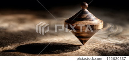 Wooden dreidel spinning on a rustic wooden table, motion blur on the spin Wooden dreidel spinning on a rustic wooden table, motion blur on the spin 133020887