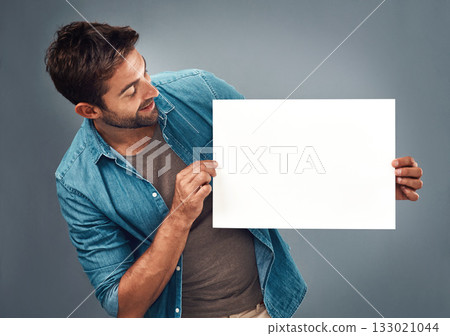 Man, billboard sign and mockup for marketing, advertising or branding against a grey studio background. Male person holding rectangle shape poster or placard for advertisement message with copy space 133021044