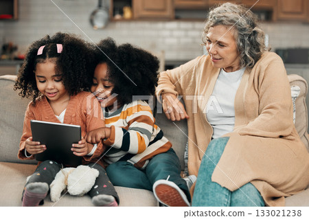 Watching, movie and children with grandmother and a tablet for games, education or website. Interracial, digital and girls playing on technology, streaming a show and film with a senior woman Watching, movie and children with grandmother and a tablet for games, education or website. Interracial, digital and girls playing on technology, streaming a show and film with a senior woman 133021238