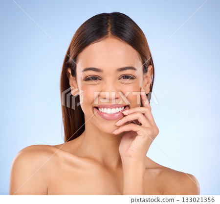 Beauty, portrait and woman with smile, dermatology and treatment against a blue studio background. Face, female and lady with joy, morning routine and skincare for grooming, clear and smooth skin 133021356