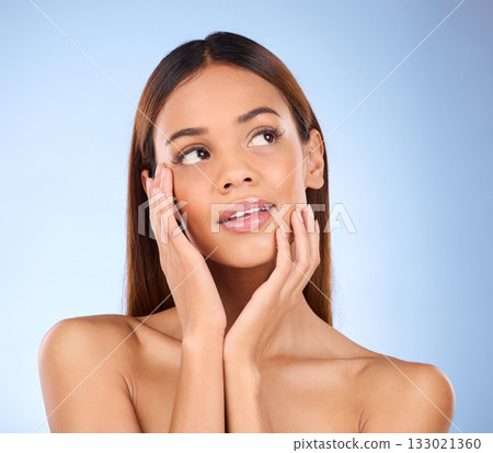 Woman, face and thinking in beauty skincare cosmetics or self love and care against blue studio background. Happy female wondering or touching perfect skin in satisfaction for facial or spa treatment Woman, face and thinking in beauty skincare cosmetics or self love and care against blue studio background. Happy female wondering or touching perfect skin in satisfaction for facial or spa treatment 133021360