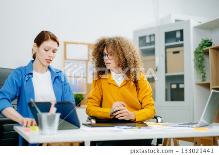 UX UI designers in modern office working on app wireframes, color palettes, and digital tools. Creative teamwork, planning, technology 133021441