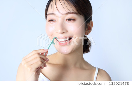 Image of a woman using dental floss Image of a woman using dental floss 133021478