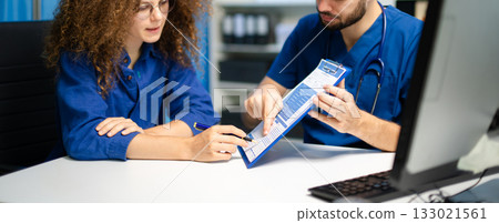 Doctor and young female patient reviewing medical form together. Concept of healthcare consultation 133021561