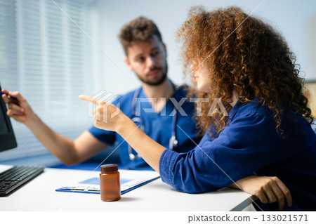 Male doctor explains health scan results to female patient using a computer screen. Concept of diagnosis, health tech, medical consultation Male doctor explains health scan results to female patient using a computer screen. Concept of diagnosis, health tech, medical consultation 133021571