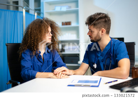 A compassionate doctor comforts a stressed female patient during a sensitive consultation. Concept of empathy, support A compassionate doctor comforts a stressed female patient during a sensitive consultation. Concept of empathy, support 133021572