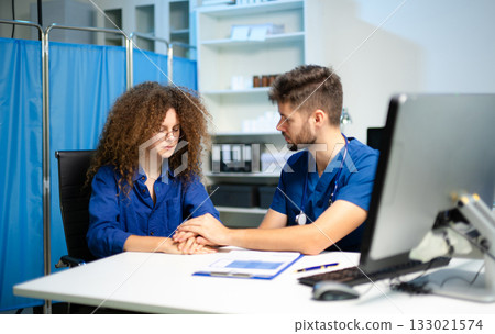 A compassionate doctor comforts a stressed female patient during a sensitive consultation. Concept of empathy, support A compassionate doctor comforts a stressed female patient during a sensitive consultation. Concept of empathy, support 133021574